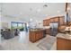 Open concept living space with kitchen island, stainless appliances, and decorative pendant lighting at 23493 Copperleaf Dr, Venice, FL 34293