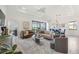 Bright and airy living room with modern furnishings, ceiling fan, and sliding glass doors leading to outdoor space at 23493 Copperleaf Dr, Venice, FL 34293