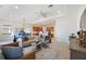 Bright open-concept living room featuring modern decor, ceiling fan, and seamless flow into the kitchen and dining area at 23493 Copperleaf Dr, Venice, FL 34293