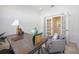 Bright home office with a desk, chair, and a cozy seating area featuring a gray armchair at 23493 Copperleaf Dr, Venice, FL 34293