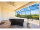 Covered patio featuring brick floors, a ceiling fan, and an outdoor seating area with a view of green space at 23493 Copperleaf Dr, Venice, FL 34293