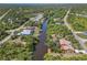 Aerial of waterfront home on canal, dock, boat lift, screened lanai, lush trees, and expansive waterways at 236 Cory St, Port Charlotte, FL 33953