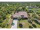 Aerial showcasing a home with screened pool, long driveway, lush surroundings, and serene privacy at 236 Cory St, Port Charlotte, FL 33953