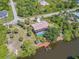 Aerial showcases waterfront home on canal, dock, boat lift, screened pool, lush trees, and expansive waterways at 236 Cory St, Port Charlotte, FL 33953