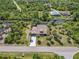 Aerial view of a waterfront home with a dock, boat lift, screened lanai, and lush landscaping at 236 Cory St, Port Charlotte, FL 33953