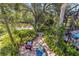 Lush backyard with brick pathway, cozy seating, and mature trees by the water at 236 Cory St, Port Charlotte, FL 33953