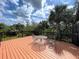 Outdoor deck with dining table and chairs overlooking lush greenery at 236 Cory St, Port Charlotte, FL 33953