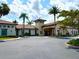 Stunning exterior view of the community clubhouse, featuring stone accents, a tile roof, and well-maintained landscaping at 236 Soliera St, Nokomis, FL 34275