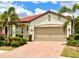 Charming single-story home with a red tile roof, two-car garage, and lush tropical landscaping at 236 Soliera St, Nokomis, FL 34275