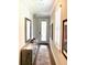 Inviting hallway featuring wood floors, a weathered console table, a decorative mirror, and natural light from the front door window at 236 Soliera St, Nokomis, FL 34275