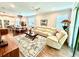 Spacious living room with wood floors, a decorative rug, and a large sectional sofa, open to the dining area at 236 Soliera St, Nokomis, FL 34275