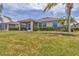 Landscaped backyard with screened in lanai and lush green lawn at 24849 Pennington Ter, Venice, FL 34293