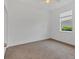 An empty bedroom featuring a large window, carpeted floor, and a closet at 24849 Pennington Ter, Venice, FL 34293