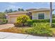 Inviting single-story home with a well-manicured lawn and a paver driveway leading to the attached two-car garage at 24849 Pennington Ter, Venice, FL 34293