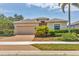 Inviting single-story home with a well-manicured lawn and a paver driveway leading to the attached two-car garage at 24849 Pennington Ter, Venice, FL 34293