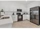 Modern kitchen with white cabinets, stainless steel appliances and tiled floors at 24849 Pennington Ter, Venice, FL 34293