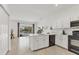 Bright kitchen features white cabinets, black appliances, and an island overlooking the water at 24849 Pennington Ter, Venice, FL 34293
