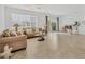 Spacious living room with large window offering scenic lake views, complemented by comfortable seating and tile flooring at 24849 Pennington Ter, Venice, FL 34293