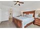 Bright main bedroom features a ceiling fan, a wood bed frame and matching nightstand at 24849 Pennington Ter, Venice, FL 34293