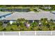 Aerial view showcases a well-maintained backyard, enclosed patio, and lush surrounding greenery at 25069 Pearl Lake Cir, Englewood, FL 34223