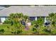Aerial view of the backyard featuring a patio with seating area, manicured lawn, and tropical landscaping at 25069 Pearl Lake Cir, Englewood, FL 34223