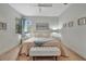 Comfortable bedroom with a large bed, two side tables, bench and neutral decor at 25069 Pearl Lake Cir, Englewood, FL 34223