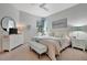 Bright bedroom features a ceiling fan, neutral walls, and a decorative bench at the foot of the bed at 25069 Pearl Lake Cir, Englewood, FL 34223