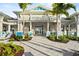 The grand clubhouse features an elegant entrance, complimented by lush landscaping and comfortable outdoor seating at 25069 Pearl Lake Cir, Englewood, FL 34223