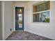 Covered porch with a glass-paneled front door and a large window allowing ample natural light at 25069 Pearl Lake Cir, Englewood, FL 34223
