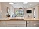 Stylish kitchen overlooking the living room offers sleek stainless steel appliances and inviting breakfast bar at 25069 Pearl Lake Cir, Englewood, FL 34223