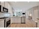 Bright kitchen featuring stainless steel appliances and an open floorplan to the living area at 25069 Pearl Lake Cir, Englewood, FL 34223