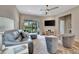 Bright living room featuring a plush couch, lounge chairs, television, and access to the outdoor patio at 25069 Pearl Lake Cir, Englewood, FL 34223