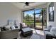 Screened patio includes comfortable seating and views of the well-maintained backyard landscaping at 25069 Pearl Lake Cir, Englewood, FL 34223