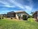 Spacious backyard with lush lawn and screened patio, ideal for outdoor living and entertaining at 25784 Grayton Ave, Englewood, FL 34223