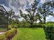 Expansive backyard featuring lush green grass and mature trees at 25784 Grayton Ave, Englewood, FL 34223