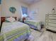Shared bedroom featuring matching twin beds, wood look floors, and cheerful blue accents at 25784 Grayton Ave, Englewood, FL 34223