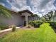 Landscaped front yard featuring lush greenery and colorful flowering shrubs at 25784 Grayton Ave, Englewood, FL 34223