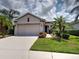 Charming single-story home with well-manicured lawn and mature palm trees at 25784 Grayton Ave, Englewood, FL 34223