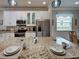 Bright kitchen features granite countertops, stainless appliances, and open layout at 25784 Grayton Ave, Englewood, FL 34223