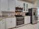 Modern kitchen featuring stainless steel appliances, white cabinets, and granite countertops at 25784 Grayton Ave, Englewood, FL 34223
