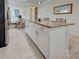 Kitchen island featuring granite countertop, white cabinets, and room for dining at 25784 Grayton Ave, Englewood, FL 34223