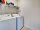 Functional laundry area with a washer, dryer, and storage shelving for convenience at 25784 Grayton Ave, Englewood, FL 34223