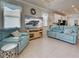 Relaxing living room showcasing comfortable seating, a large TV, and beach-inspired accents at 25784 Grayton Ave, Englewood, FL 34223