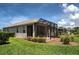 Relaxing screened patio with black frame and a view of the lush backyard at 25784 Grayton Ave, Englewood, FL 34223