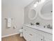Well-lit bathroom with dual sinks, white vanity, and framed circular mirrors at 2614 River Preserve Ct # 2614, Bradenton, FL 34208