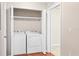 Laundry room with a white washer and dryer set inside an open closet with a wood floor and white trim at 2614 River Preserve Ct # 2614, Bradenton, FL 34208
