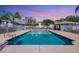 Community pool surrounded by palm trees and a white picket fence at sunset at 2614 River Preserve Ct # 2614, Bradenton, FL 34208