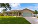 Charming single-story home with a well-manicured lawn, blue shutters and a two-car garage at 30 Jamestown Ave, Englewood, FL 34223