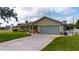 Single Gathering home showcasing a well kept lawn, tidy landscaping, and an extra wide driveway at 30 Jamestown Ave, Englewood, FL 34223