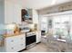Bright kitchen featuring white cabinets, stainless steel appliances, and a bay window dining area at 30 Jamestown Ave, Englewood, FL 34223